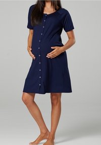 Mörkblå gravidklänning i mjukt tyg, med korta ärmar och knappfront. Klänningen har en lös passform och når knäna.