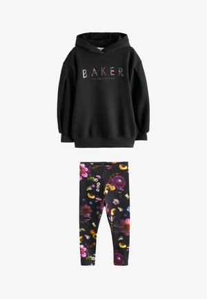 Sort hoodie med multicolor "BAKER by Ted Baker" tekst, parret med sorte leggings med livlige blomster Mønstre i lilla, gult og pink.