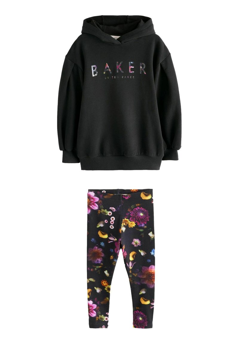 Čierna mikina s kapucňou s viacfarebným textom "BAKER by Ted Baker" v kombinácii s čiernymi legínami s živými kvetinovými vzormi v purpurovej, žltej a ružovej farbe.