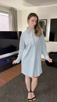 Φόρεμα πουκάμισο από γαλάζιο κορδούρα ύφασμα με μακριά μανίκια και γιακά, με χαλαρή εφαρμογή και ρέλι με κουμπιά. Φορεμένο με μαύρα σανδάλια με λουράκια.