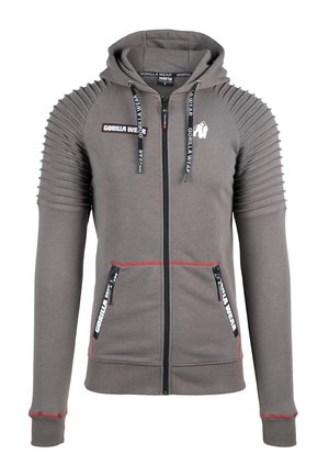 Grijze zip-up hoodie met geribbelde schouderontwerpen, rode accenten en contrasterende ritsen. Voorzien van twee zijzakken en een gevoerde capuchon.