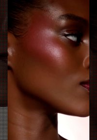 Profile view of a woman with warm skin tone, illuminated highlights on the cheek, subtle sheen, and medium-length dark hair styled back.