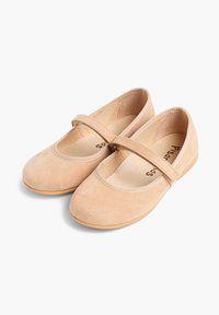 Bailarinas de ante beige claro con punta redonda, correa elástica en el empeine y suela de goma plana. Interior etiquetado con el nombre de la marca.
