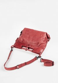 Rode leren crossbody tas met een slouchy ontwerp, verstelbare schouderband en opvallende stiksels en hardwaredetails.