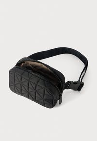 Borsetta a vita nera trapuntata con chiusura a zip, superficie testurizzata, tracolla regolabile e design minimalista. L'interno presenta una fodera liscia.