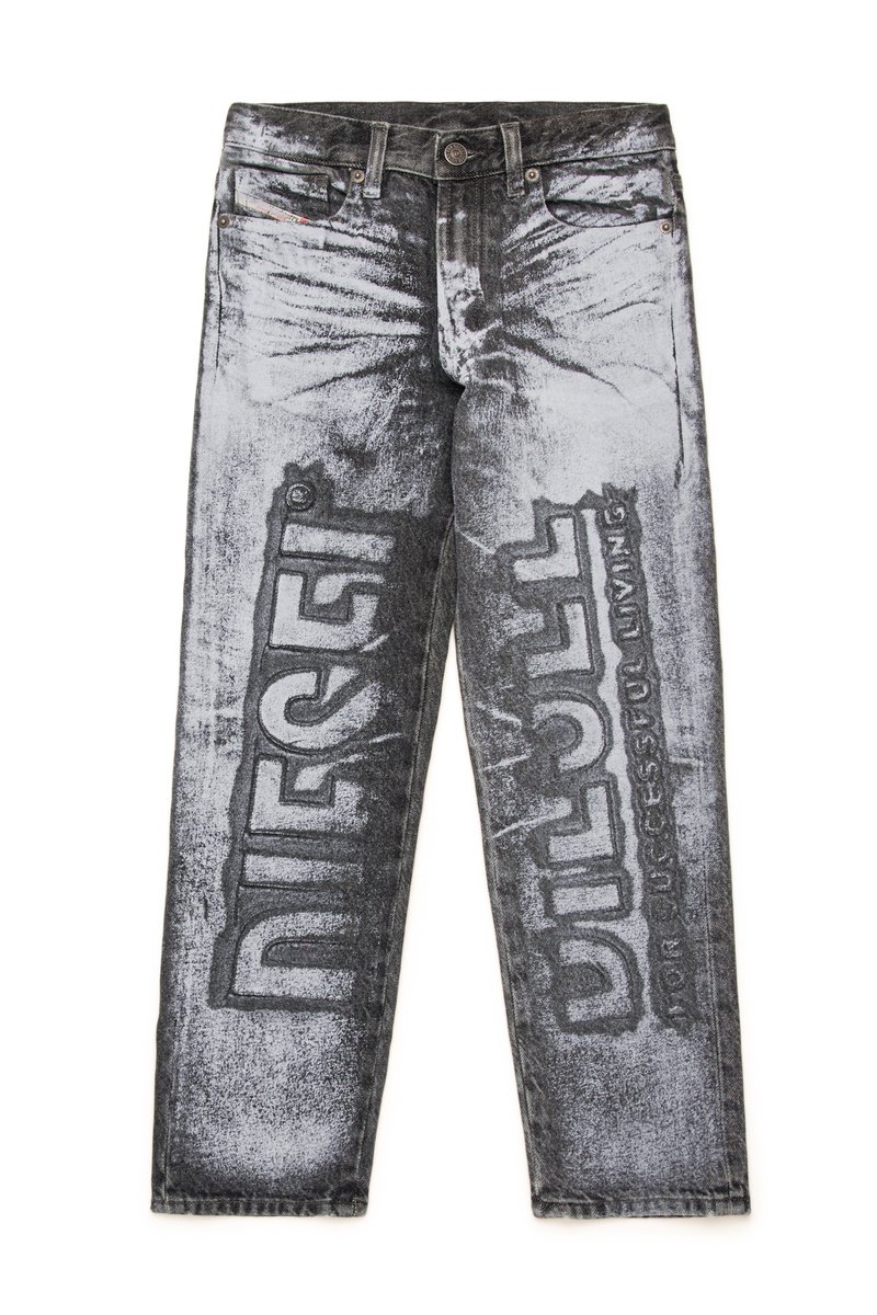 Calças de ganga preto e cinza com um acabamento desgastado, apresentando grande texto impresso "DIESEL" e "DILL" nas pernas, contrastando com áreas desbotadas.