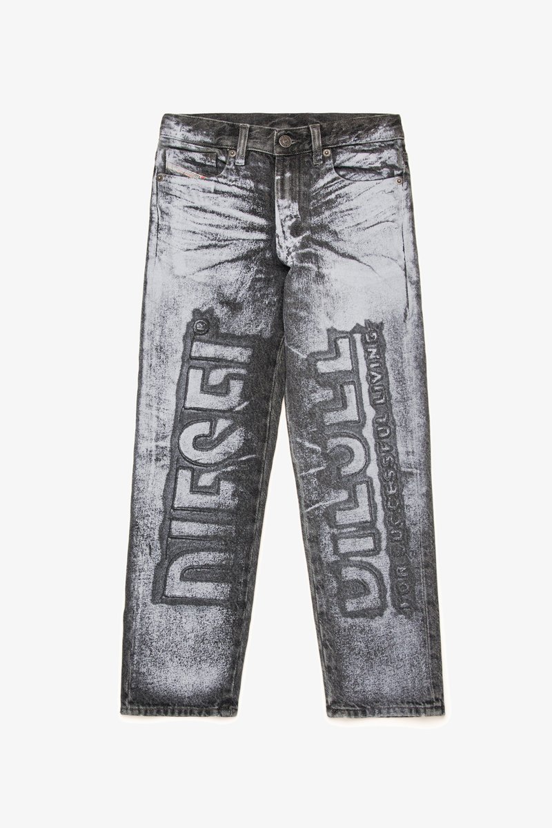 Calças de ganga preto e cinza com um acabamento desgastado, apresentando grande texto impresso "DIESEL" e "DILL" nas pernas, contrastando com áreas desbotadas.
