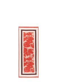 Foulard à motifs floraux rouges avec de grandes feuilles, encadré de bordures sombres et claires contrastantes. Fabriqué en tissu doux et texturé.