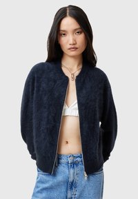 Marineblaue Bomberjacke aus flauschigem Strickmaterial mit Reißverschluss und geripptem Kragen. Verfügt über fallende Schultern und eine lockere Passform.