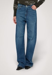 Högmidjade, vida blå jeans i denim med en ren finish, ljus blekhet och femficksdesign med bältesömmar.