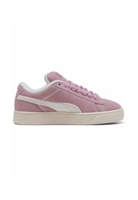 Adidași Puma din suede de culoare roz deschis cu accente albe, superior texturat, șireturi rotunde și talpă din cauciuc cu un model de uzură.
