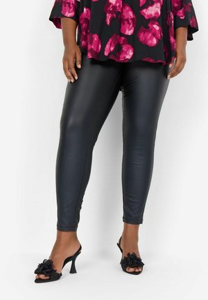 Black faux leather leggings with a slim fit, paired with black open-toe heels featuring floral accents. The top has a floral pattern in pink and red.