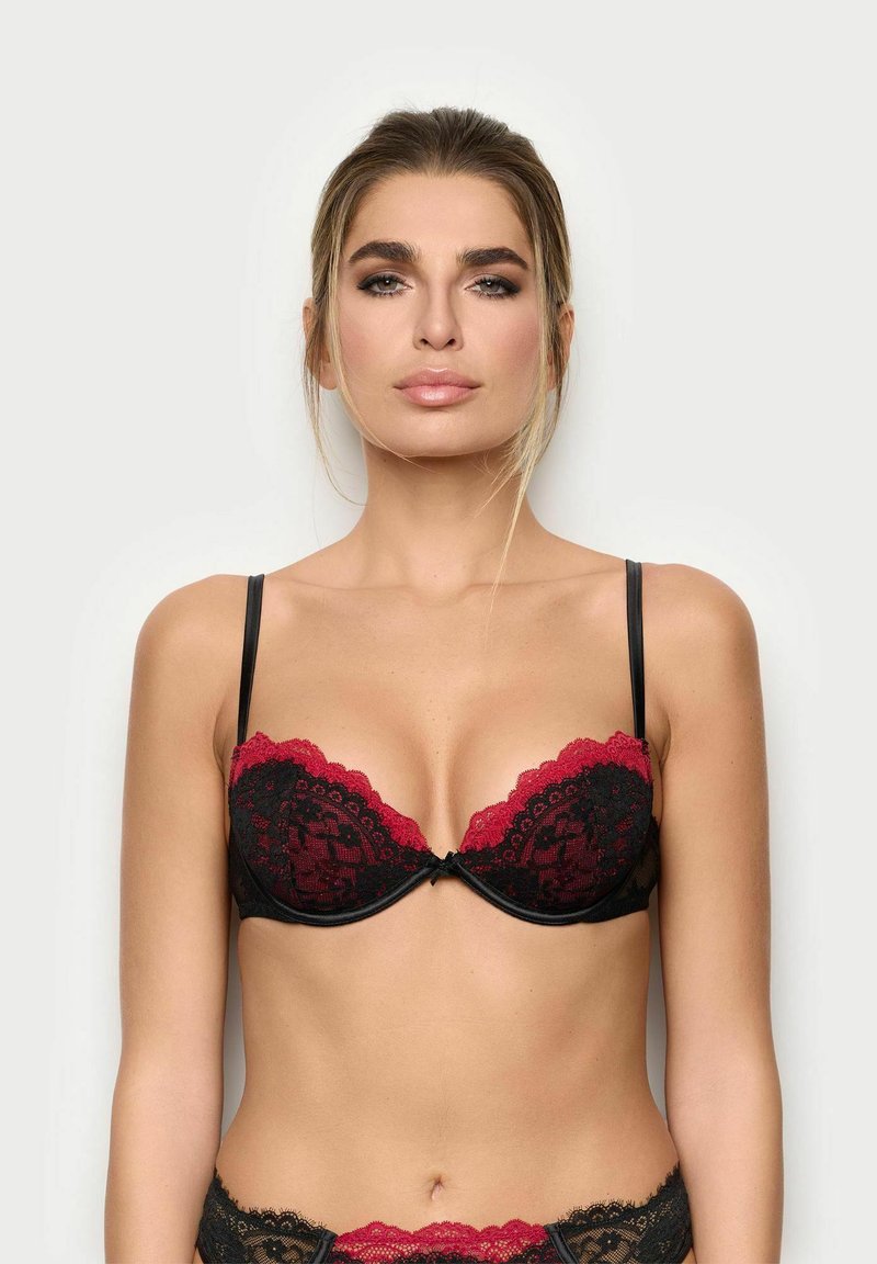 Sort blonde bh med rød bølget kant, med underwire støtte og justerbare stropper. Detaljerne inkluderer en sløjfe i midten.