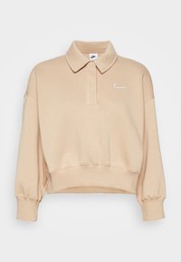 Sweatshirt polo court beige avec un col, des manches longues, des poignets et un ourlet en côte. Présente un petit logo Nike blanc sur la poitrine gauche.