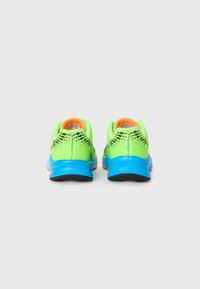 Neon green athletic shoes with a mesh upper, blue midsole, and orange accents. Rear view shows distinctive black patterned design.