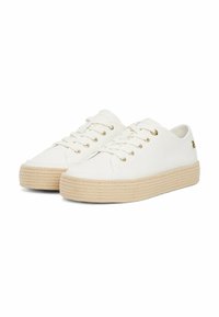 Weiße Leinenschuhe mit goldenen Ösen, dicker beigefarbener Sohle, runder Zehenpartie und minimalem Branding. Schnürsenkel und flaches Design.