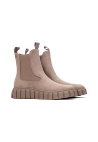 Stivali ankle in suede beige con pannelli elastici laterali, linguette per un facile indossamento e suola in gomma rigata per una migliore trazione. Presentano un design elegante e minimale.