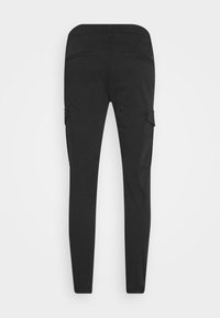 Pantalon cargo noir slim avec poignets élastiques, poches passepoilées à l'arrière et poches à rabat sur les côtés, vu de dos sur un fond uni.