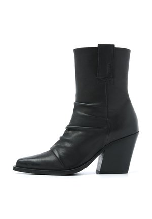 Black leather ankle boot with a pointed toe, slouchy design, and a clear block heel. Features a back pull tab for easy wear.