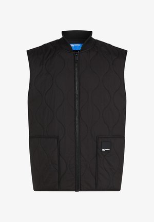 Vest reciclabil negru, matlasat, fără mâneci, cu fermoar pe față, având un gât rotund, două buzunare frontale și o eticheta cu marcă în partea din dreapta jos.