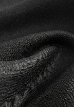 Țesătură neagră care prezintă o textură netedă cu variații subtile în suprafață. Materialul pare a fi ușor și șifonat în anumite zone.