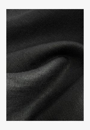 Țesătură neagră care prezintă o textură netedă cu variații subtile în suprafață. Materialul pare a fi ușor și șifonat în anumite zone.