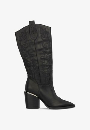 Stivale da cowboy in pelle nera con intricati motivi di cucitura. Presenta una punta appuntita e un tacco a blocco con un accento metallico alla base.