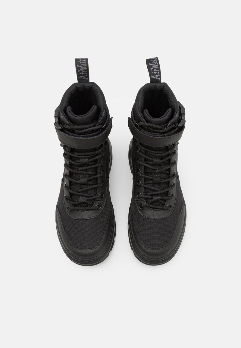 Zapatillas altas negras con parte superior de tela texturizada, tobillo acolchado, cordones y correa ajustable. Suela de goma con un diseño elegante.