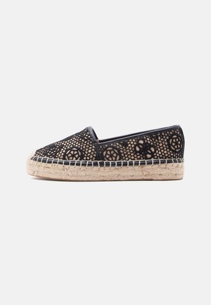 Espadrilla in pizzo nero con suola intrecciata beige e motivi floreali circolari su sfondo bianco, vista laterale.