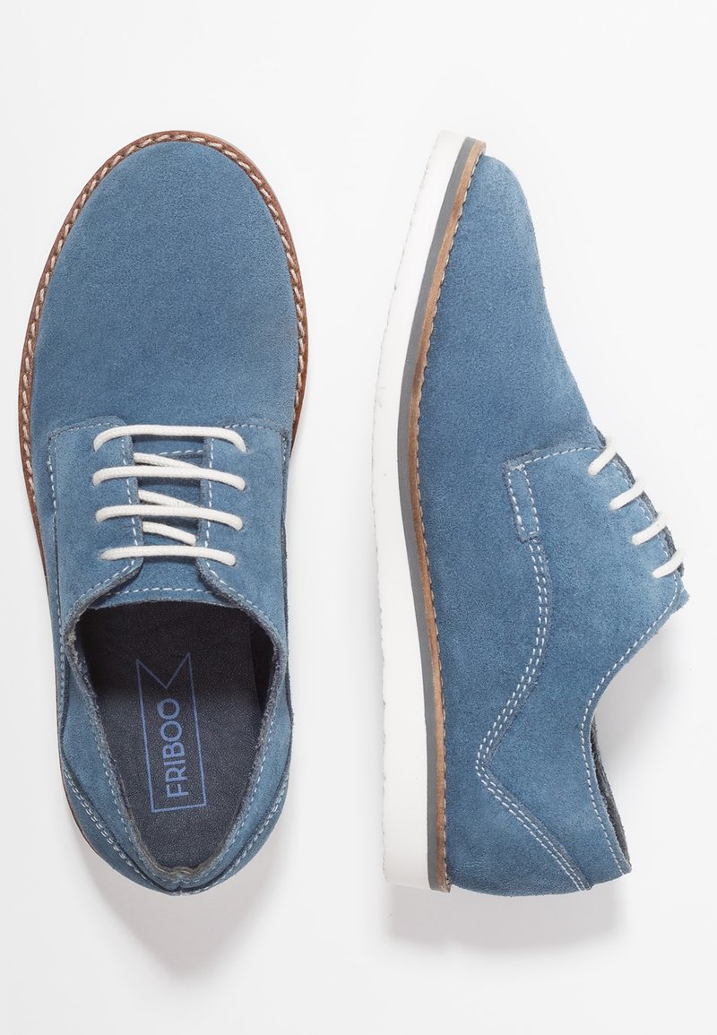 Scarpe da dress in camoscio blu con lacci bianchi, suole avorio e dettagli marroni. Presentano un design classico con cuciture decorative.