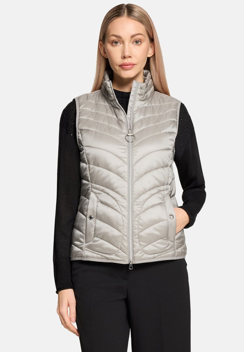 Veste sans manches isolante gris clair avec un design matelassé, col montant et fermeture éclair à l'avant. Comprend deux poches latérales et une texture de tissu élégante.