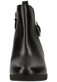 Bottine en cuir noir avec boucle latérale et fermeture éclair, bout rond et semelle plate vue de face.
