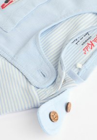 Helles blaues Kleidungsstück aus gestreiften Stoff mit gerippter Textur. Verfügt über Knopfverschlüsse und bestickte Details. Weiches Baumwollmaterial.