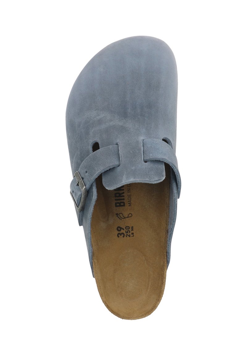 Sabot en daim bleu à dos ouvert, doté d'une bride unique avec boucle. L'intérieur est beige avec des marquages de taille. Texture lisse.