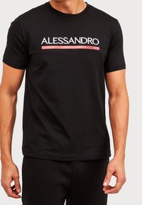 Camiseta de algodón negra de manga corta, con el texto "ALLESSANDRO" en blanco y rojo que atraviesa el pecho, cuello redondo y un ajuste relajado.