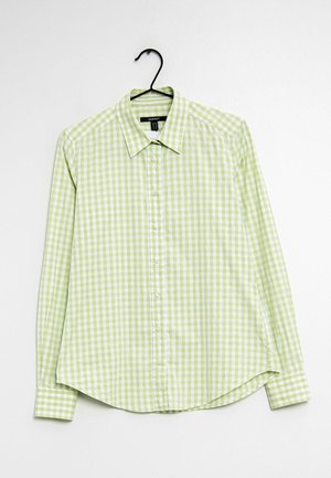 Long-sleeve button-up shirt with light green and white checkered pattern hanging on black hanger.