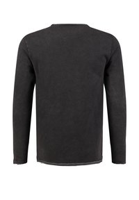 Zwart shirt met lange mouwen van zacht stof. Heeft een ronde halslijn en een gestikte zoom. Eenvoudig, minimalistisch ontwerp zonder patronen of accenten.