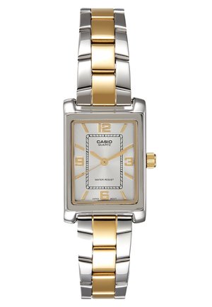 Montre-bracelet rectangulaire Casio argent et or à quartz avec index des heures dorés, bracelet métallique doré et argenté, et fonction étanche.