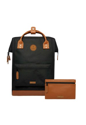 Black backpack with tan leather accents, featuring a top handle, zippered front pocket, and a matching tan pouch. Durable material and structured design.