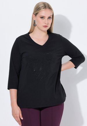 T-shirt noir à col en V avec des manches trois-quarts, présentant un design texturé orné de strass intégrés sur le devant.