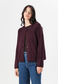 Bordeaux cardigan laget av mykt, teksturert stoff, med rund hals, lange ermer og frontlukking med knapper.