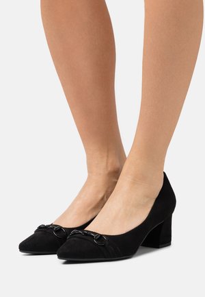 Chaussures à talons hauts en suede noir avec un léger bout carré, arborant des détails en chaîne à l'avant et un talon bloc moyen.