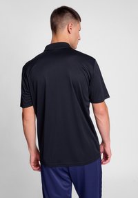 Svart polo-shirt med kort ärm design, med en enkel krage och slät yta, sedd bakifrån.