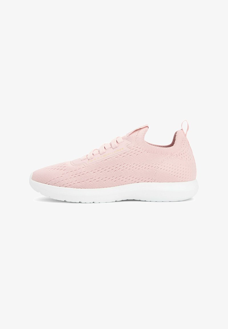 Baskets de sport en tricot rose clair avec semelle blanche, lacets et languette à l'arrière, vues de profil sur un fond blanc.