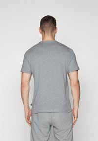 Grå kortærmet t-shirt lavet af bomuldsblandning, med rund hals og en afslappet pasform, vist fra ryggen.