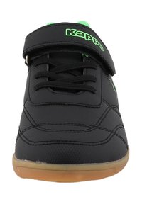 Schwarzer Sportschuh mit grünem Logo, verstellbarem Klettverschlussriemen, strukturiertem synthetischen Obermaterial, Gummisohle und kontrastierenden Nähten.