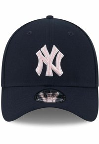 Marineblaue Baseballmütze aus Stoff mit einem gestickten, rosa New York Yankees-Logo. Sie hat einen gebogenen Schirm und ein verstellbares Etikett für die Passform.