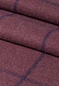 Teksturowana tkanina w głębokim burgundowym kolorze z prążkowanym wzorem, z delikatnym niebieskim siatkowym designem. Miękki i ciepły materiał, złożony.