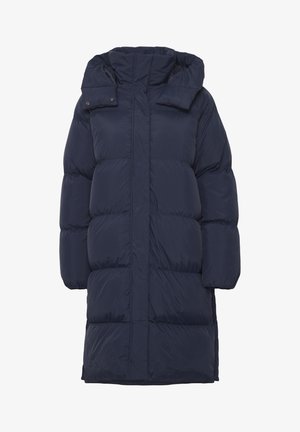Manteau long matelassé bleu marine avec un col haut et des boutons-pression. Possède une texture matelassée et une coupe droite pour la chaleur et la protection.