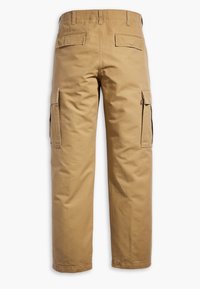 Vue arrière d’un pantalon cargo beige avec passants de ceinture, deux poches arrière à rabat et des poches cargo latérales sur chaque jambe.